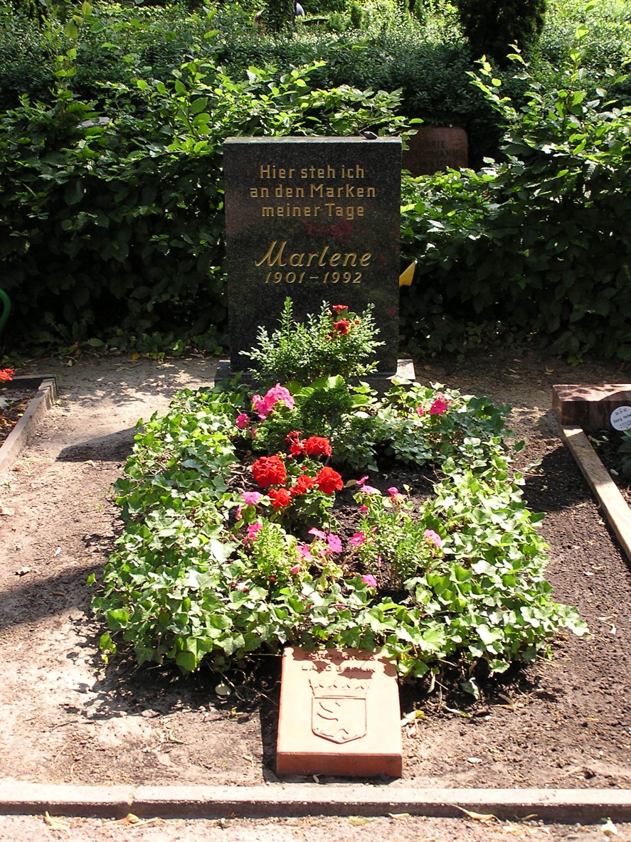 Nagrobnik Marlene Dietrich v Berlinu z napisom »Tukaj stojim ob mejnikih svojih dni«.